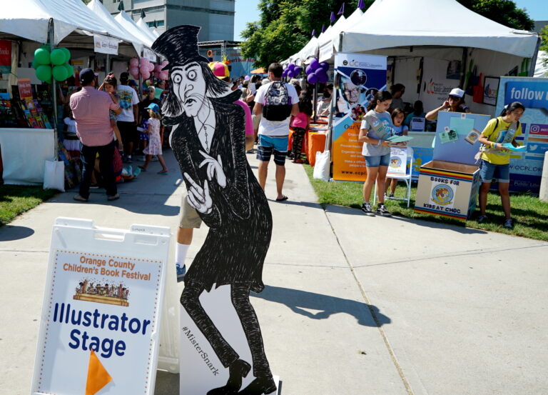 2018 O.C. Children's Book Festival - Mister Snark Lurking Next To Illustrator Stage Sign